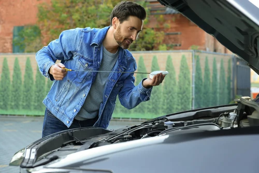 Motoröl prüfen, Mann kontrolliert Ölstand am Auto, Tipps zur richtigen Motoröl Wahl.